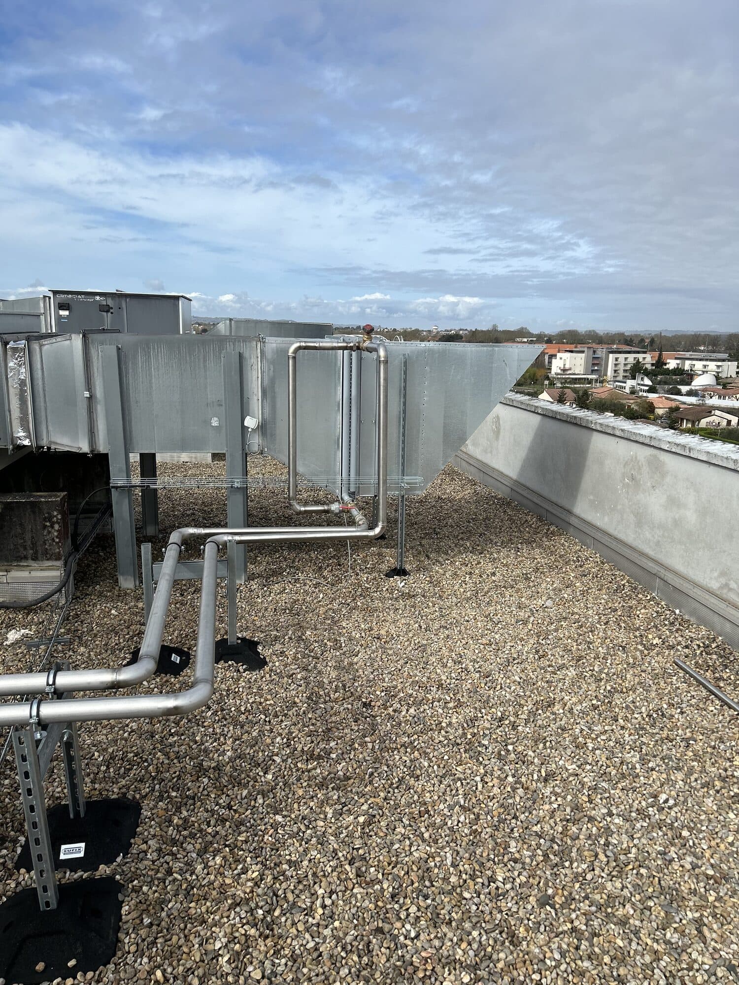 Réseau de tuyauterie industrielle installé en extérieur sous un ciel bleu